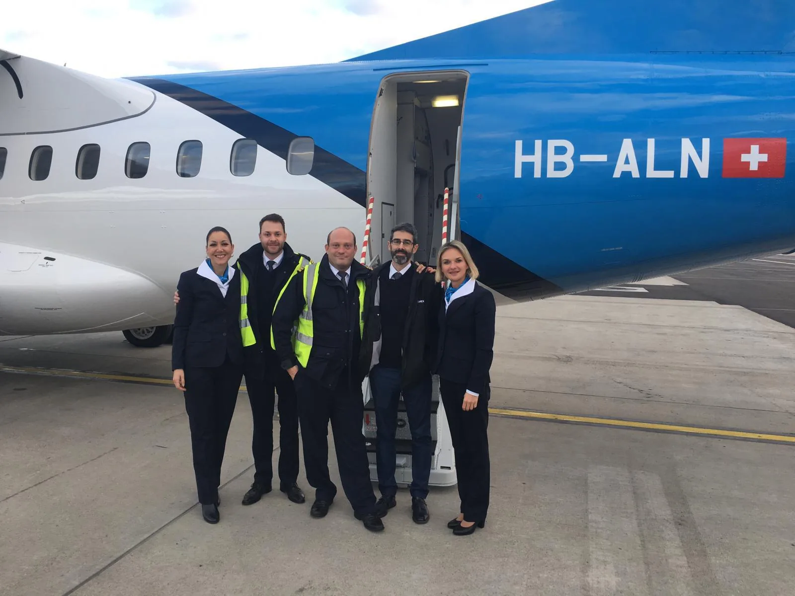 Five Zimex pilots and cabin crew in uniform in front of the ATR 42-500 HB-ALN.