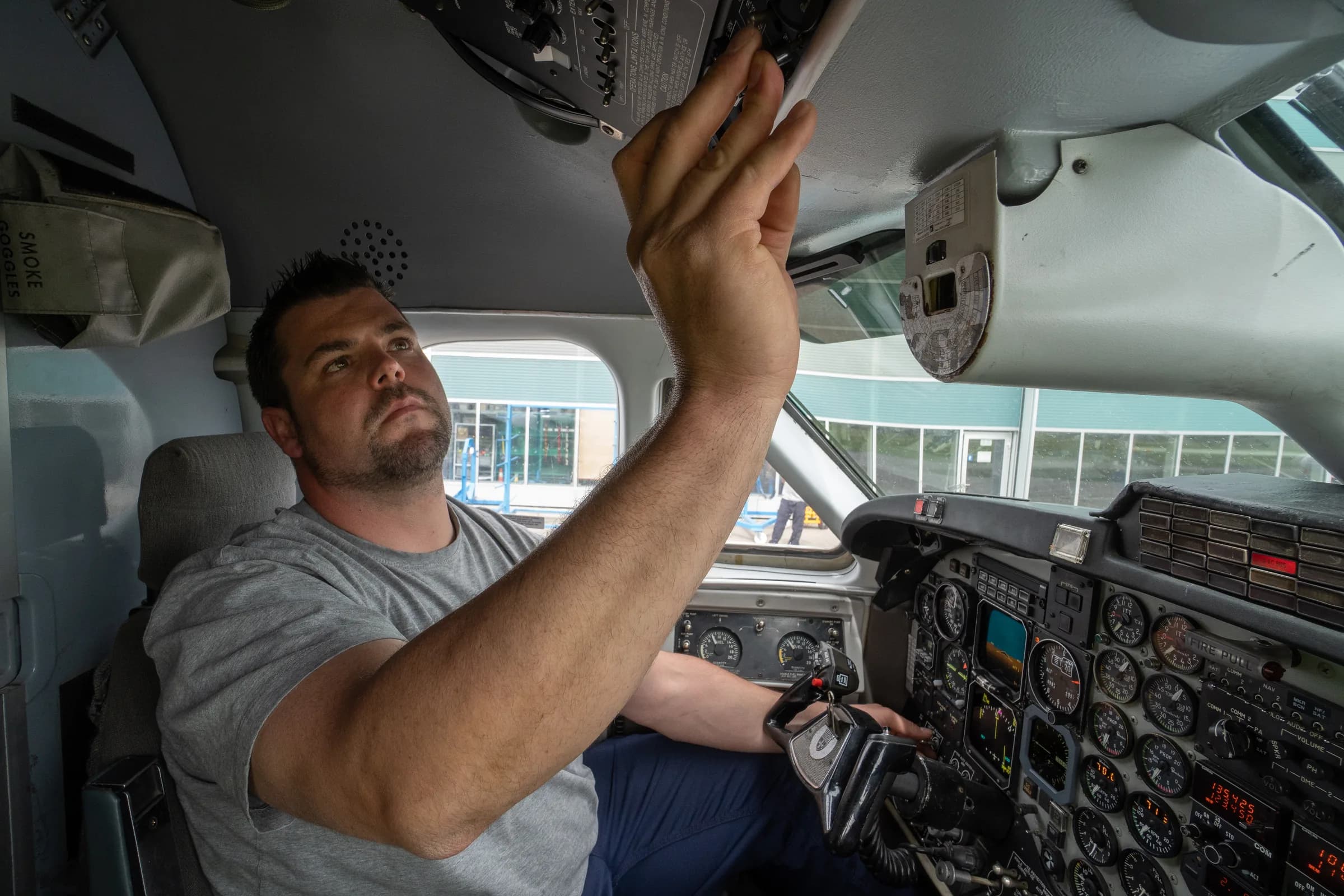 A Zimex engineer working on the overhead panel in a Twin Otter flight deck at Altenrhein.