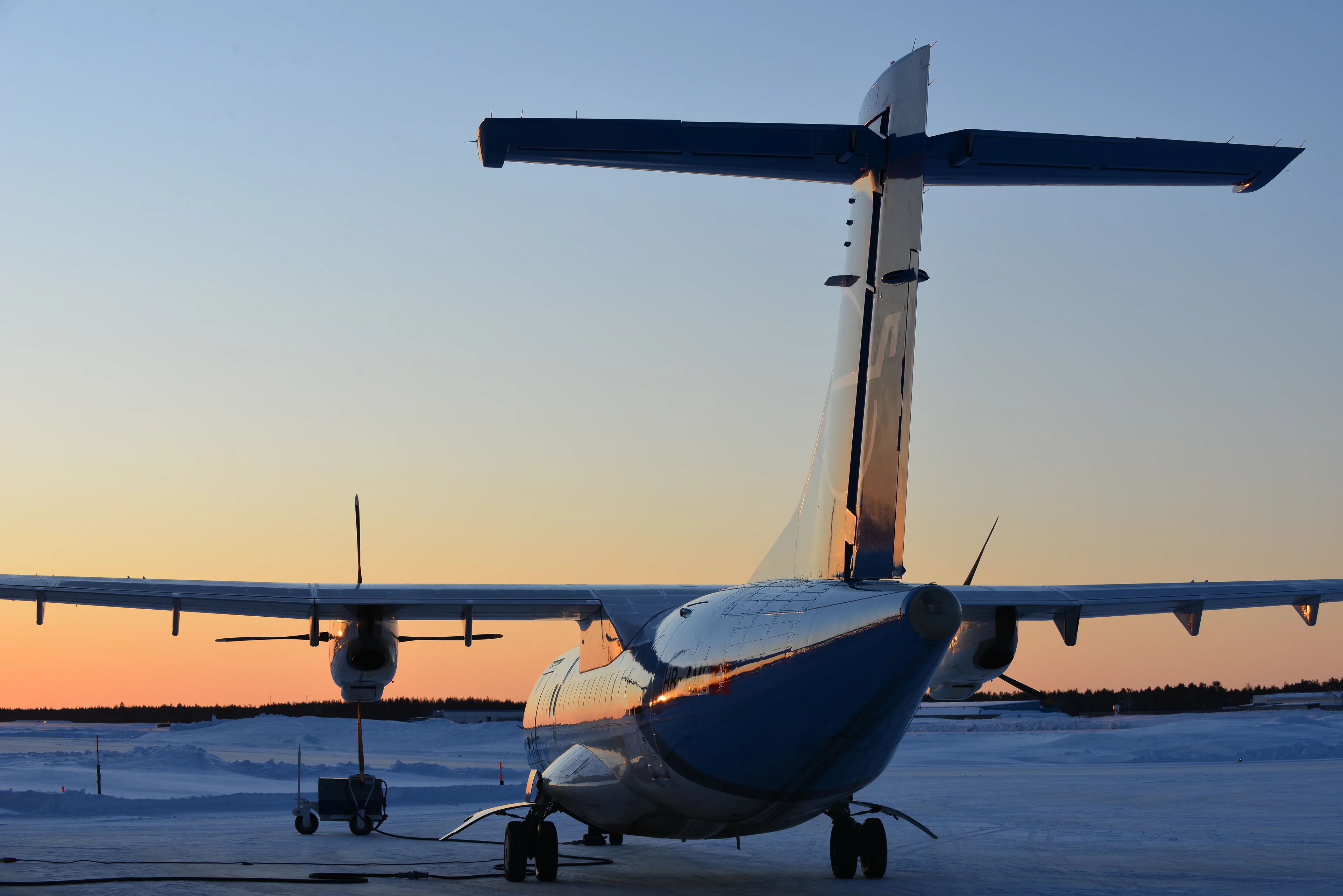 A Zimex ATR 72 freighter at sunrise on a snowy apron in Sweden