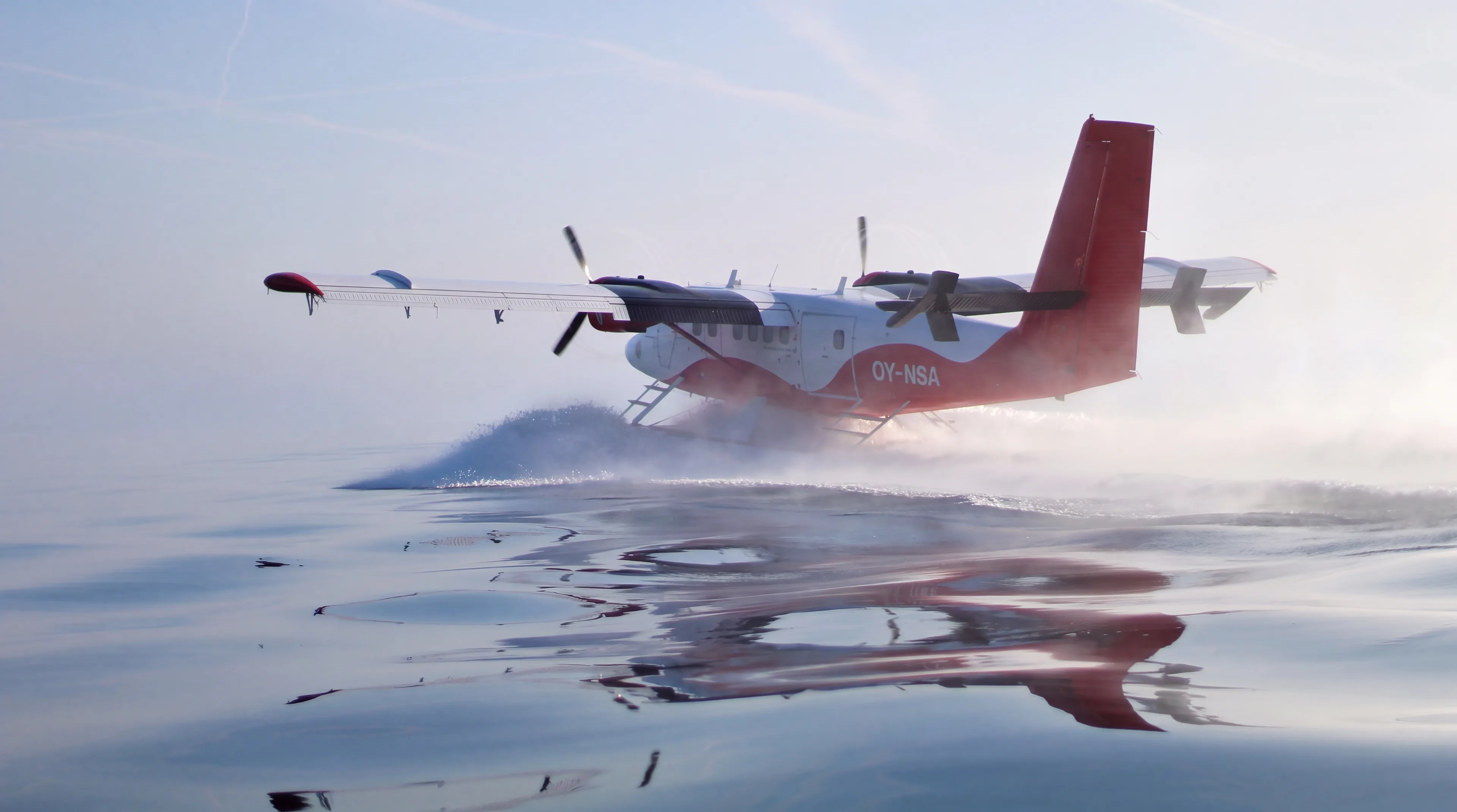 Nordic Seaplanes Twin Otter taking off from calm water