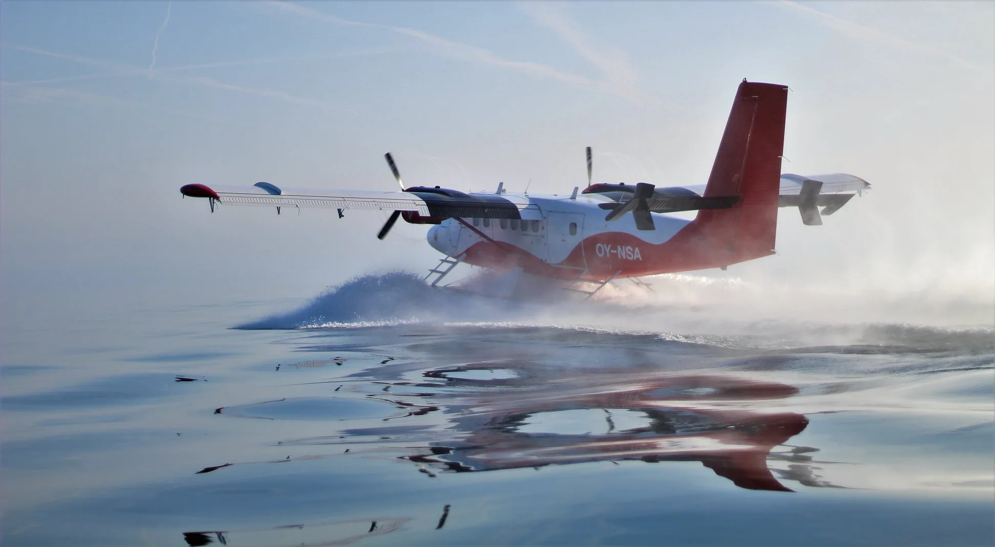 A float Twin Otter of Nordic Seaplanes taking off from the water.